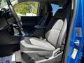 A 2021 Chevrolet Colorado interior featuring a driver's side seat with a patterned fabric and leather design, armrest, and gear shift console in the front cabin area