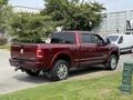 A red 2024 RAM 3500 pickup truck parked with a chrome grille and large wheels showcasing its rugged design and features
