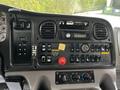 Interior dashboard of a 2010 Freightliner M2 106 with controls for transmission radio and various instrumentation including warning lights and air conditioning settings
