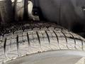 A close-up view of a tire with detailed tread patterns mounted on a vehicle