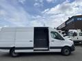 A white 2025 Mercedes-Benz Sprinter van with an open side door revealing the interior space