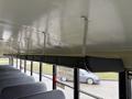 Interior view of a 2013 International 3000 school bus showing overhead handrails and a row of empty seats