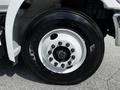 A close-up of a black tire mounted on the wheel of a 2020 Hino 338 showing distinct lug nuts and a white wheel rim