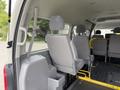 Interior view of a 2009 Toyota Hiace showing gray seats with seatbelts and a storage compartment on the side