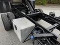 A 2011 Ford F-550 truck chassis featuring large wheels and an aluminum diamond plate toolbox mounted on the frame