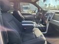 Interior view of a 2014 Ford F-150 with black fabric seats and a central console featuring controls and a gear shift