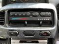 Dashboard controls of a 2003 Mitsubishi Delica displaying various buttons for climate control and audio system