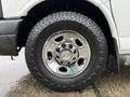 Close-up of a silver wheel on a 2021 Chevrolet Express featuring a shiny chrome hubcap and a black Hankook tire with tread visible
