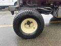 A close-up of a tire from a 2010 Kubota F3680 featuring a white rim and a black treaded tire marked with the brand name Earlstar