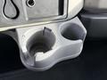 A gray cup holder with a textured surface and two compartments designed for holding cups or beverages in a vehicle's interior