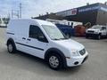 A 2010 Ford Transit Connect van in white with a sliding side door and black accents parked on a concrete surface