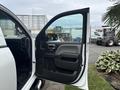 A 2016 GMC Sierra 1500 with the driver's side door open revealing the interior features and controls