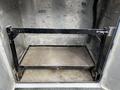 Interior of a truck compartment showing a metal frame and a flat platform designed for storage or equipment transport