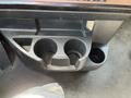A close-up view of the cup holders in a 2022 Freightliner Cascadia featuring two large circular compartments and one smaller circular compartment