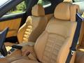 Tan leather seats of a 2005 Ferrari 612 Scaglietti with sporty design and a distinctive headrest showcasing the Ferrari logo