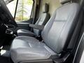 Gray leather seats inside a 2015 Ford Transit van with adjustable armrests and a spacious cabin design