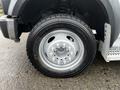 A close-up of a silver wheel and tire of a 2009 Ford F-550 showing the tire tread and wheel design