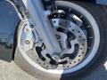 Close-up of a 2004 Harley-Davidson Flhtcui front wheel featuring a silver brake caliper and a detailed brake disc with perforations