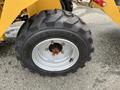 Close-up of a tire from a 2024 AGT Industrial KRW23 Mini Loader featuring a black tread pattern and silver rim with visible bolts and a red center hub
