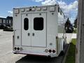 A white 2013 Chevrolet Express with a high roof and double rear doors featuring reflective lights and a chrome bumper