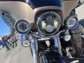 A 2004 Harley-Davidson Flhtcui motorcycle with prominent headlights and chrome detailing in the foreground