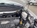 The engine compartment of a 2014 Chevrolet Express showing the engine block various hoses and components including the brake fluid reservoir