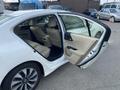 A 2017 Honda Accord Hybrid with a white exterior and beige leather seats visible inside featuring an open rear door