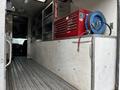 A 2006 GMC C5000 truck interior featuring a red tool chest and blue air hose with metal shelving along the sides