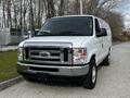 A white 2014 Ford Econoline van with a chrome front grille and large headlights