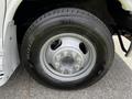 A close-up of a wheel from a 2013 Chevrolet Express showing a silver rim with multiple bolts and a Bridgestone Blizzak tire