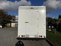 A 2017 Freightliner M Line truck with a large white box trailer features a rear door and light fixtures on the bottom corners