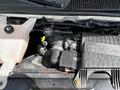 Engine compartment of a 2013 Chevrolet Express showing components like the coolant reservoir and engine parts including the Vortex intake manifold