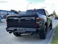 A black 2019 RAM 1500 truck viewed from the rear showcasing its bold design and large tires
