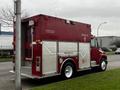 A red 1995 Freightliner FL70 fire rescue truck featuring white accents and a pink breast cancer awareness ribbon on the side