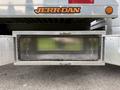 A storage compartment with a diamond plate design on a 2022 Ford F600 truck's bed with the JERR-DAN logo above it