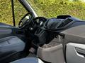 Interior dashboard and driver seat of a 2015 Ford Transit featuring a modern design with multiple controls and storage compartments