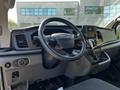 Interior view of a 2023 Ford Transit showing the steering wheel dashboard and control panel with touchscreen display and various knobs and buttons