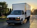 A white 2015 GMC Savana box truck with a large empty cargo area and black front grille positioned at an angle
