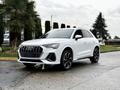 A white 2024 Audi Q3 with a distinctive grille and sleek design parked at an angle showcasing its sporty appearance and modern features