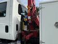 A 2008 International 4300 truck with a crane attachment on the side featuring various control panels and levers