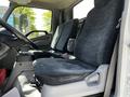 Interior view of a 2018 Hino 195 showing two gray fabric seats and the driver's console with a steering wheel and gear shift