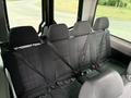 The interior seats of a 2017 Mercedes-Benz Sprinter with three rows of black seats equipped with seatbelts