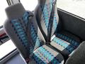 Interior seats of a 2022 Blue Bird BB Conventional bus featuring grey fabric with blue and teal patterns and safety seatbelts