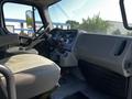 Interior view of a 2004 Freightliner M2 showing the driver's seat dashboard and controls