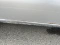 A close-up view of a silver 2010 Ford Econoline showing rust along the lower edge of the body near the door