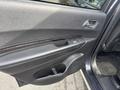 The interior door panel of a 2015 Dodge Durango featuring a black design with a silver handle and a control button for the windows