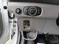 Control panel of a 2022 Ford Transit featuring buttons for lights and a compartment for storage