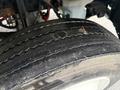 Close-up of a worn tire from a 2019 Freightliner M2 displaying visible tread wear and dust accumulation on the surface