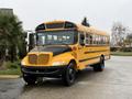 A yellow 2013 International 3000 school bus with a black front and large windows parked with an open door
