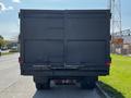 A black 2016 Isuzu NPR box truck viewed from the rear with closed doors and a visible bumper
